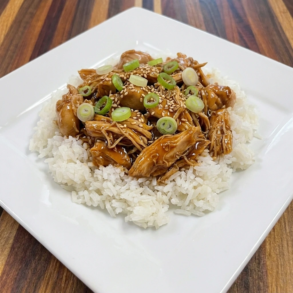 Single serving of Crockpot Teriyaki Chicken over fluffy white rice with sesame seeds