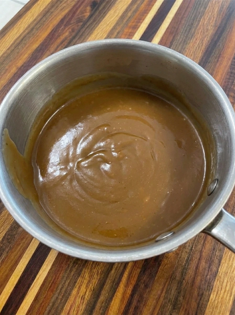 Smooth savory turkey gravy warmed in a small saucepan